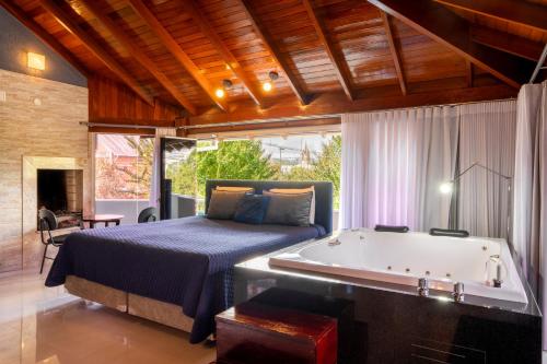 a bedroom with a bed and a bathtub next to a bed and a tub at FIKA Residence in Dois Irmãos