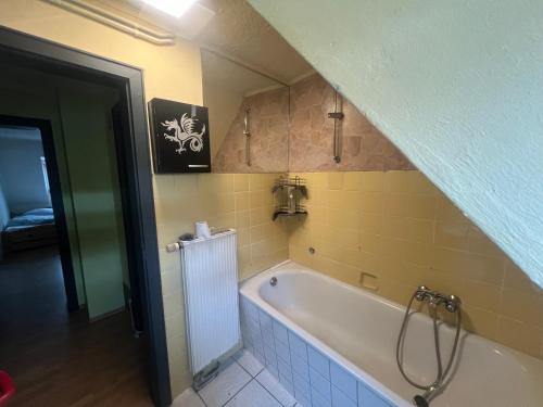 a bath tub in a bathroom with yellow tiles at Wohnung 6 Hagenerstr 72 Siegen 57072 in Siegen