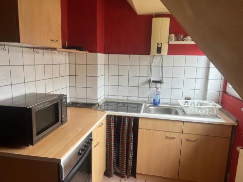 a small kitchen with a sink and a microwave at Wohnung 6 Hagenerstr 72 Siegen 57072 in Siegen
