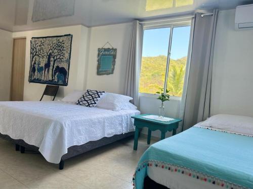 1 dormitorio con 2 camas y ventana en Miss Francia´s Home, en Santa Catalina Island