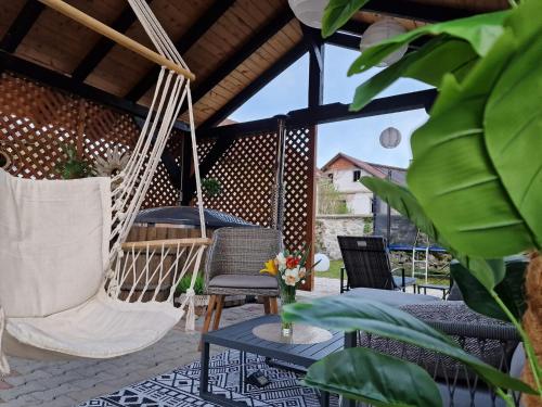 a hammock on a patio with chairs and a table at Holiday House Tina in Čabar