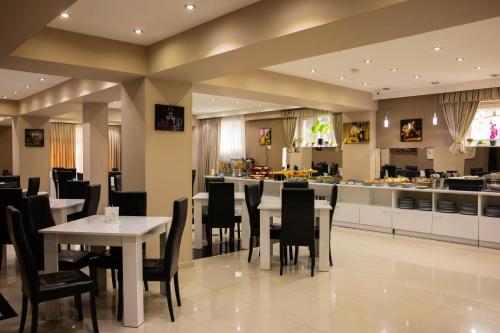 un restaurante con mesas, sillas y una barra en Hotel Grand Palace, en Tiflis