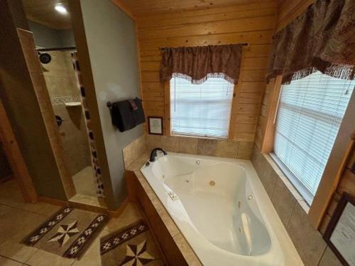 Thunderbird Lodge في Burnet: حمام كبير مع حوض استحمام ودش
