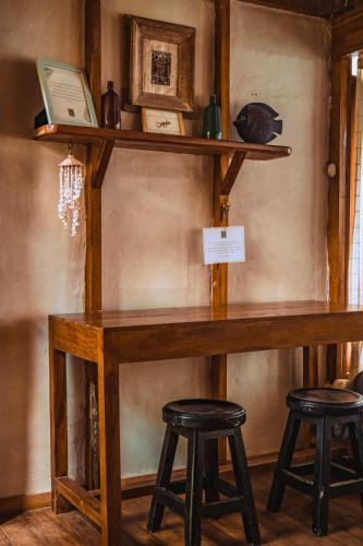 a wooden table with two stools in a room at Coco Ne in Máncora