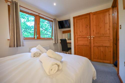 a bedroom with a white bed with towels on it at Lodge Nine Beautiful Holiday Lodge in Devon in Chudleigh