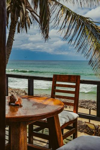 a table and chairs on a beach with the ocean at Coco Ne in Máncora