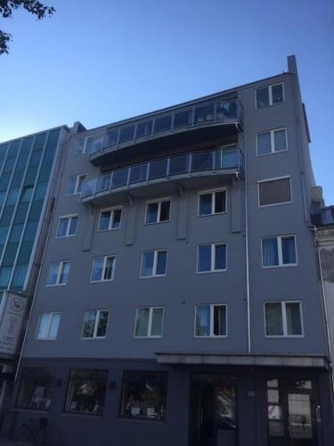 Un grand bâtiment gris avec de nombreuses fenêtres. dans l'établissement Leilighet i hjertet av kristiansand sentrum!, à Kristiansand