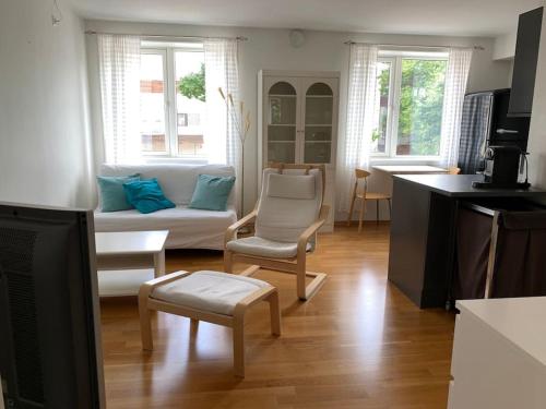 - un salon avec un canapé et des chaises dans l'établissement Leilighet i hjertet av kristiansand sentrum!, à Kristiansand