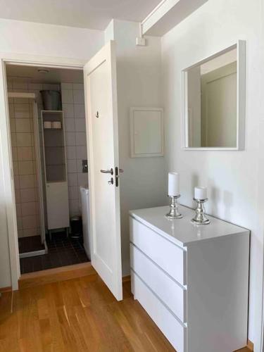 La salle de bains est pourvue d'une commode avec un miroir et un lavabo. dans l'établissement Leilighet i hjertet av kristiansand sentrum!, à Kristiansand