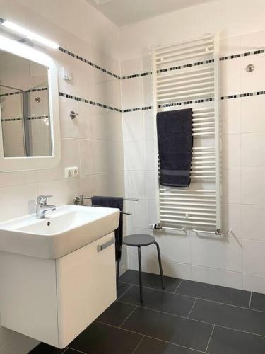 a bathroom with a sink and a mirror and a stool at Ferienhaus direkt an der Hase in Quakenbrück