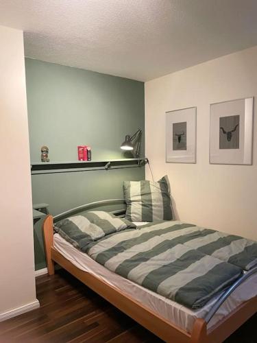 a bedroom with a bed with a striped comforter at Ferienhaus direkt an der Hase in Quakenbrück