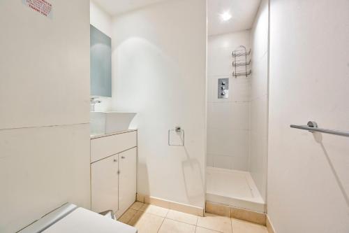a white bathroom with a shower and a toilet at That Cosy Stay - Fantastic 2 Bed Apartment - Stratford in London