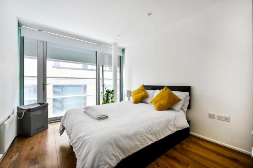 a bedroom with a large bed with yellow pillows at That Cosy Stay - Fantastic 2 Bed Apartment - Stratford in London