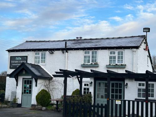a white building with a black roof at Tafarn y Waen - Guesthouse in St Asaph