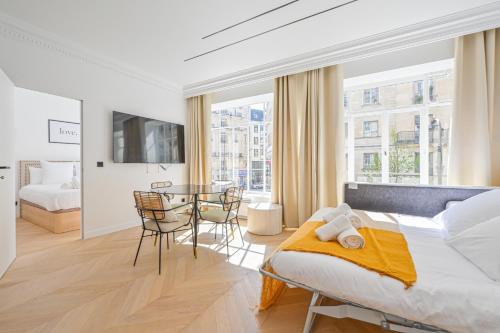1 dormitorio con 1 cama, mesa y sillas en Lovely & Exclusive Parisian Flat, en París