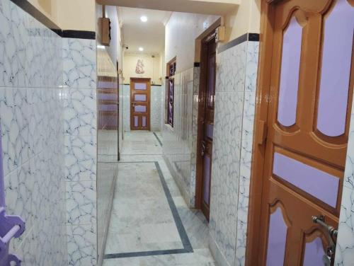 a hallway with a door and a tile floor at Anirudha Guest House in Digha