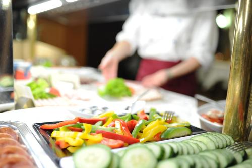 a buffet line with a plate of food with vegetables at Best Western Plus Kurhotel an der Obermaintherme in Bad Staffelstein