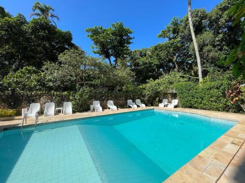 a swimming pool with lounge chairs and a resort at Hotel Solar das Águas Cantantes in Ubatuba