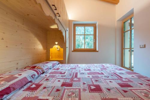 a bedroom with a bed with a quilt on it at Casa dei Caprioli in Pera