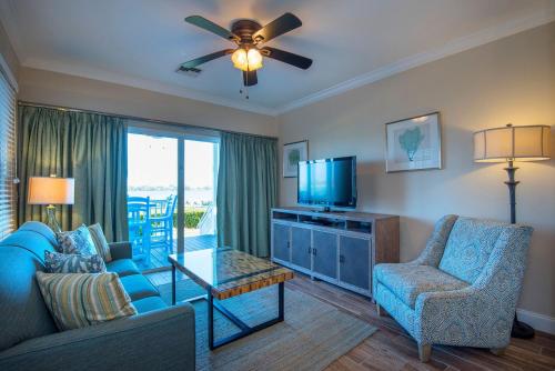 a living room with a blue couch and a tv at Hawks Cay Resort in Marathon