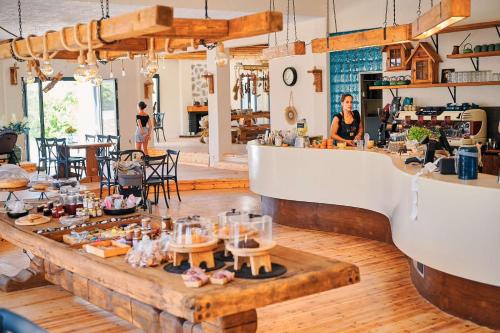 a woman is standing behind a counter in a store at Naxos green Village hotel in Naxos Chora