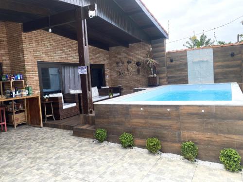 a large swimming pool in a house with a patio at Hostel Pé na Areia in Itanhaém