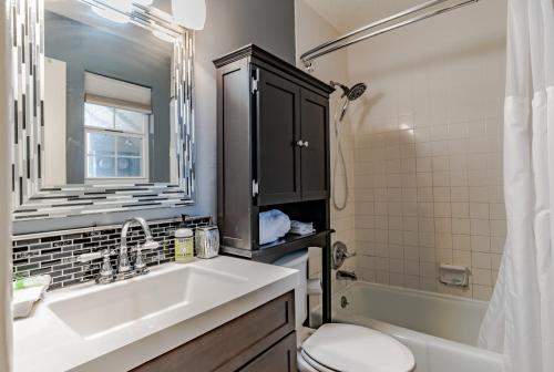 a bathroom with a sink and a toilet and a mirror at East End Beach Side Bungalow in Dauphin Island