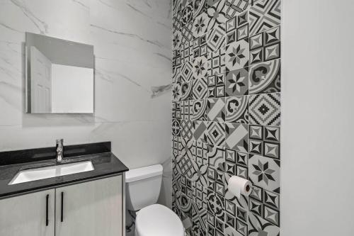 uma casa de banho com um WC, um lavatório e um espelho. em 3-Bedroom 3rd-Floor Ocean-View Condo em Coco