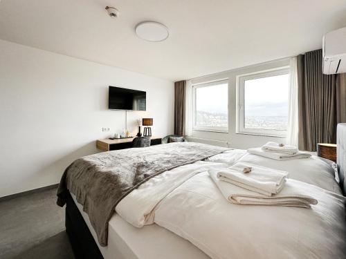 a white bedroom with a large bed with a window at SI-View Doppelzimmer mit Stadtblick Zimmer 18 in Siegen