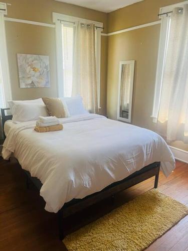 a bedroom with a bed with white sheets and a window at Historical Hideaway at Jacksonville in Jacksonville