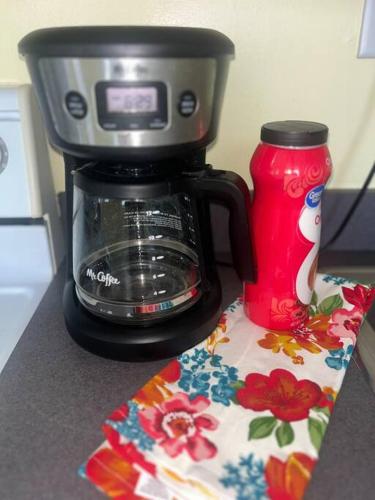 a coffee maker on a counter next to a red cup at Historical Hideaway at Jacksonville in Jacksonville