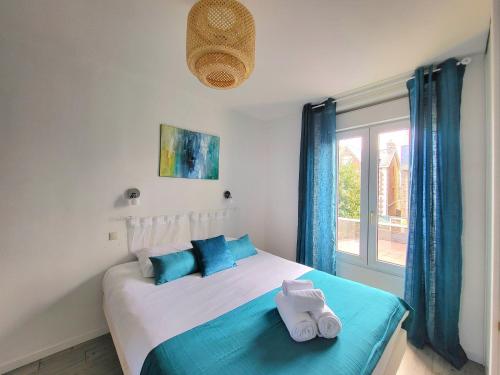 a bedroom with a bed with towels on it at Swann - A 2 pas de la plage ! in Saint Malo