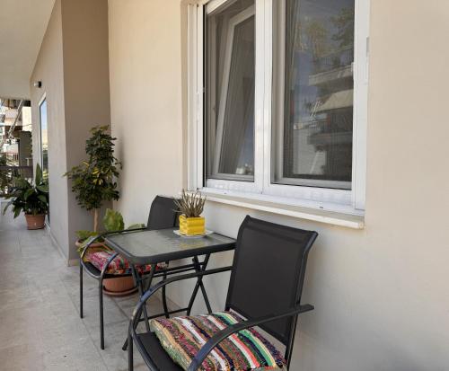 a table and chairs on a balcony with a window at Navaro Apartments in Patra
