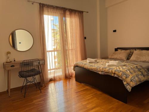 a bedroom with a bed and a table and a mirror at Navaro Apartments in Patra