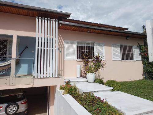 una casa con un coche aparcado delante de ella en Excelente Quarto prox centro Criciuma, en Criciúma