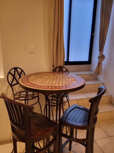 une table et des chaises dans une pièce avec une fenêtre dans l'établissement Gite A.M Hoche, à Lançon-Provence