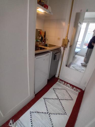 une petite cuisine avec une porte menant à un évier dans l'établissement Paris 11 Studio, à Paris