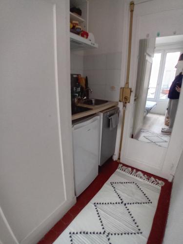 Il comprend une petite cuisine équipée d'un évier et d'un lave-vaisselle. dans l'établissement Paris 11 Studio, à Paris