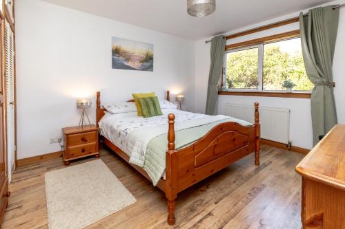 a bedroom with a bed and a window at The Fisherman's Cottage in Bunavoneader