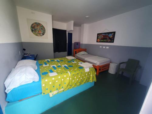 カルタヘナ・デ・インディアスにあるHotelito La Aventura, AC private WC rooms near the old town, no taxのベッドルーム1室(黄色と青の掛け布団付きのベッド1台付)