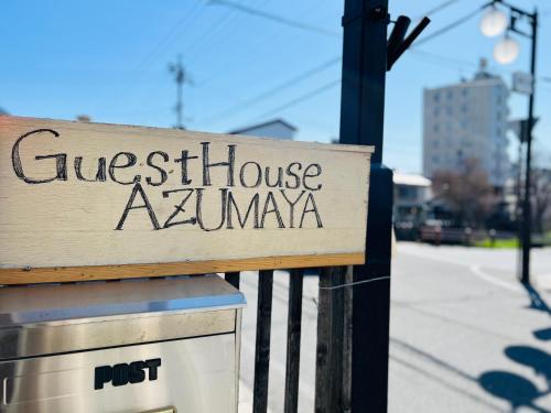 a sign for a guest house akumwa on a fence at Guesthouse Azumaya in Matsumoto