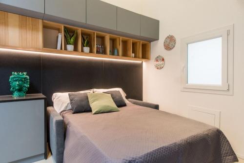 um quarto com uma cama com uma cabeceira castanha em Politeama Central Flat em Palermo