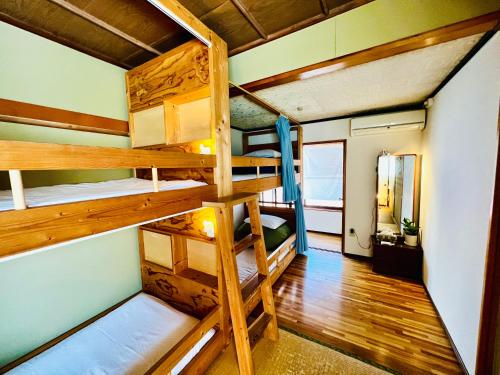 a room with bunk beds in a tiny house at Guesthouse Azumaya in Matsumoto