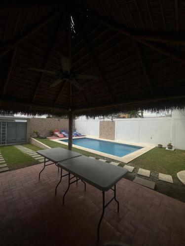 a patio with a table and a swimming pool at Casa Gaviota Casa Con Alberca y Palapa in Tequesquitengo