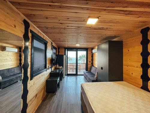 a bedroom with a bed in a room with wooden walls at Bitez Tiny House & Beach in Bodrum City