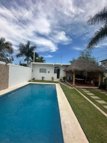 a swimming pool in front of a house at Casa Gaviota Casa Con Alberca y Palapa in Tequesquitengo