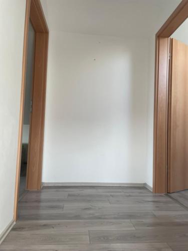 an empty room with white walls and wooden doors at Dach Zimmer D1 in Falkenberg