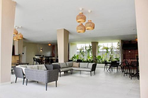 eine Lobby mit Sofas, Stühlen und Tischen in der Unterkunft Encantador Apartamento a minutos del Centro Urbano in Punta Cana
