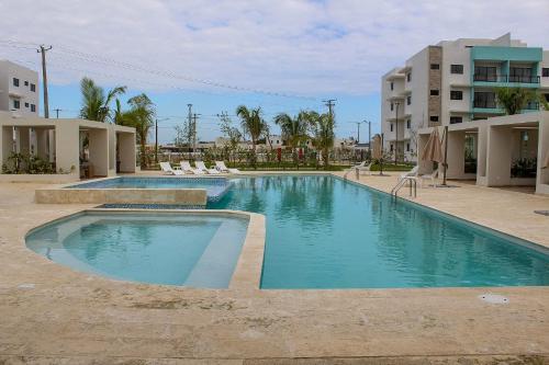 ein Schwimmbad in der Mitte eines Gebäudes in der Unterkunft Encantador Apartamento a minutos del Centro Urbano in Punta Cana