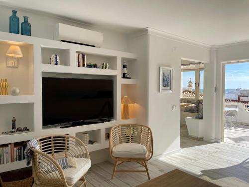 sala de estar con TV de pantalla plana y 2 sillas en Ocean Balcony en Albufeira